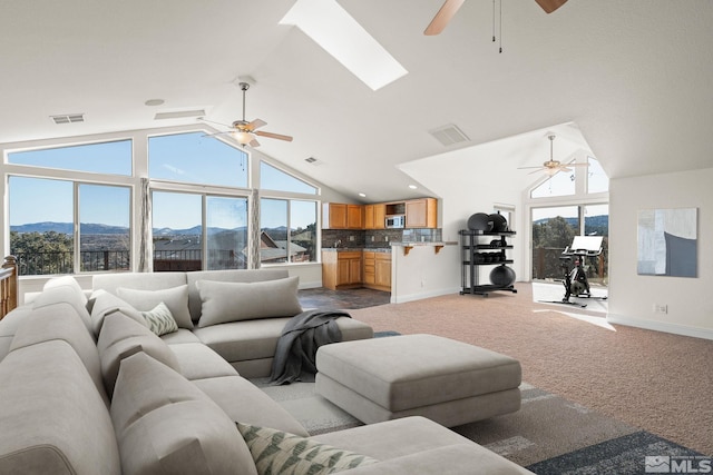 living area featuring plenty of natural light, carpet, visible vents, and a mountain view