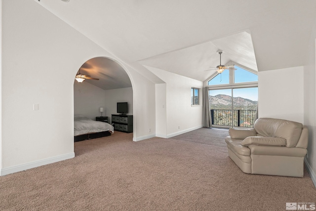 unfurnished room featuring arched walkways, high vaulted ceiling, a ceiling fan, baseboards, and carpet