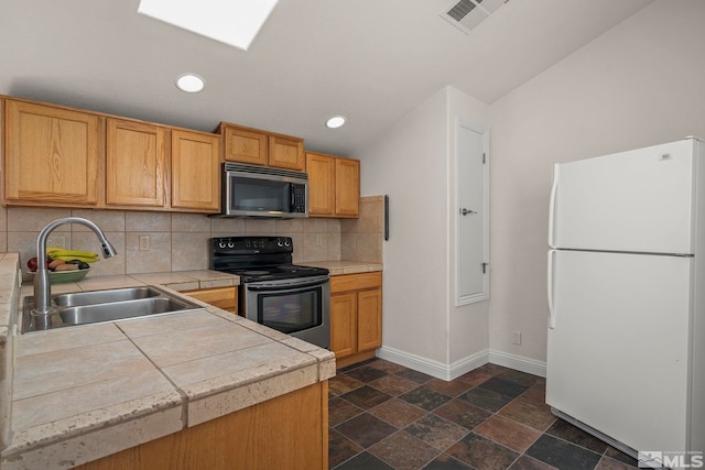 kitchen with baseboards, visible vents, appliances with stainless steel finishes, a sink, and backsplash