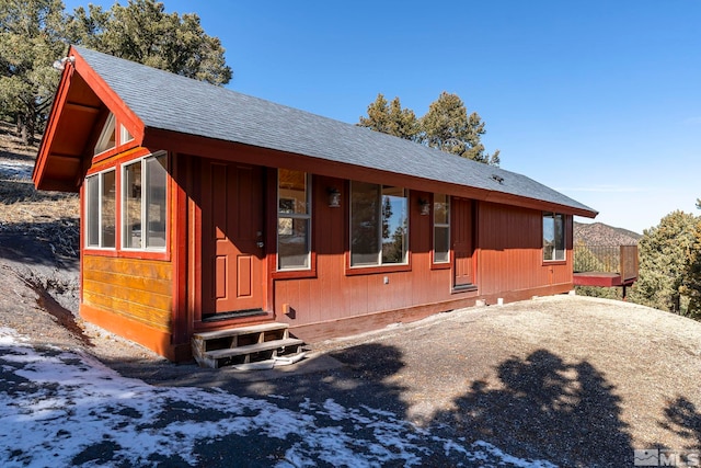 view of front of property featuring entry steps and roof with shingles