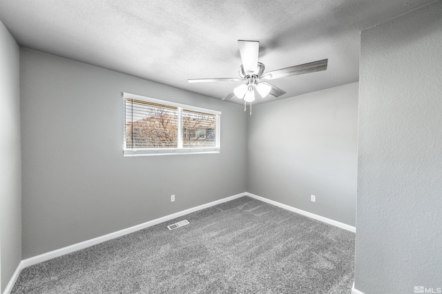 carpeted spare room with a ceiling fan, visible vents, a textured ceiling, and baseboards