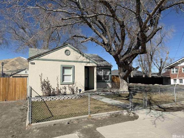 view of front of house with fence private yard, a gate, a front lawn, and stucco siding