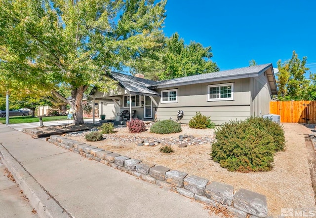 view of front of home with a garage, driveway, and fence