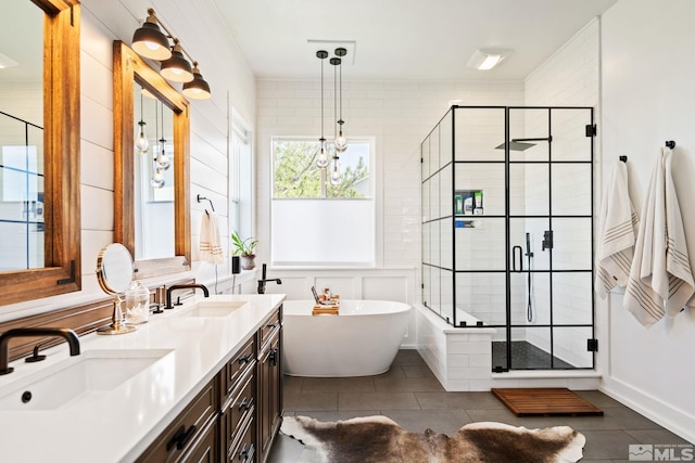 full bathroom featuring double vanity, a freestanding tub, a sink, and a stall shower