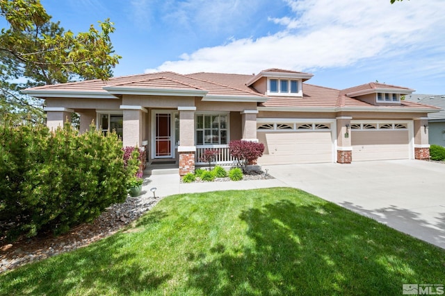 prairie-style home featuring a porch, a garage, concrete driveway, stucco siding, and a front yard