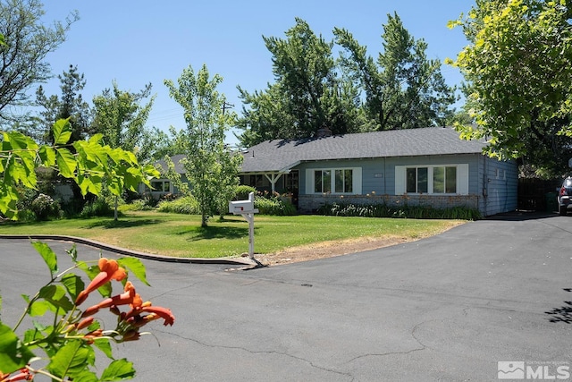 ranch-style house with driveway and a front yard