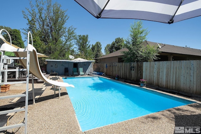 view of pool featuring a water slide, a patio area, a fenced backyard, and a fenced in pool