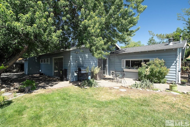 back of house with a patio area and a lawn