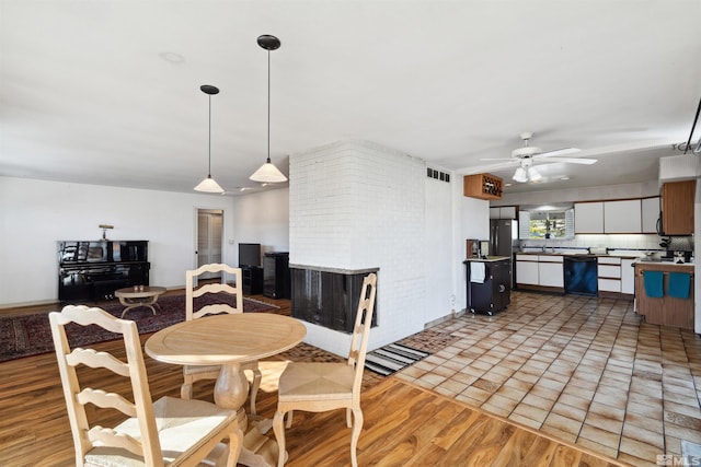 dining room with light wood-type flooring, ceiling fan, and visible vents