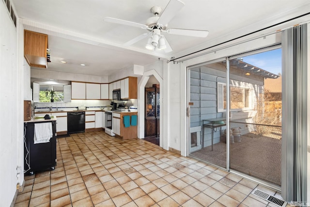 kitchen featuring visible vents, white cabinets, light countertops, decorative backsplash, and black appliances