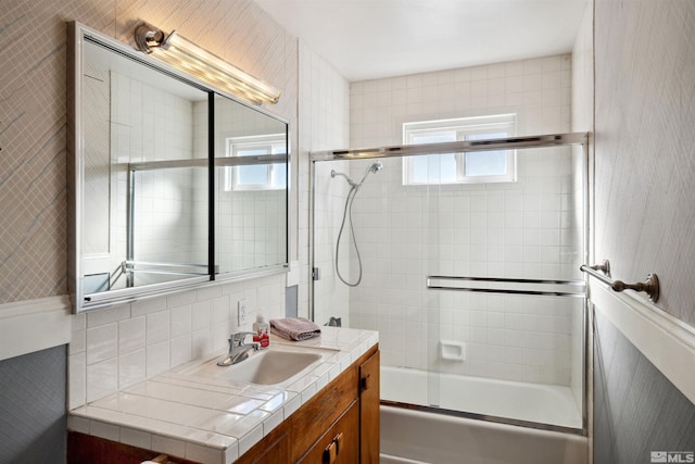 bathroom featuring vanity and bath / shower combo with glass door