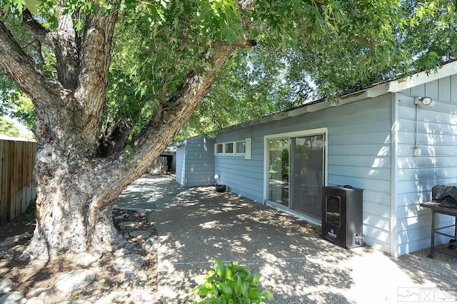 view of home's exterior with a patio area and fence