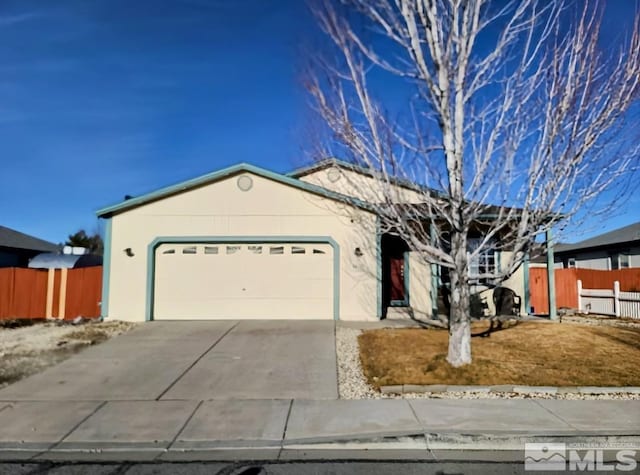 single story home with concrete driveway, fence, an attached garage, and stucco siding