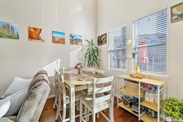 dining space featuring dark wood-type flooring and baseboards