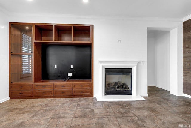 unfurnished living room with baseboards, crown molding, and a glass covered fireplace