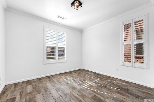 empty room with ornamental molding, baseboards, visible vents, and dark wood-type flooring