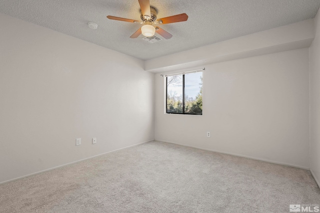 spare room with a ceiling fan, carpet, and a textured ceiling