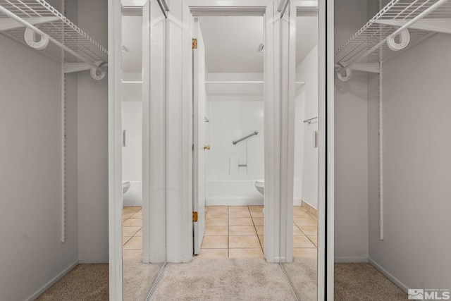 spacious closet featuring light colored carpet and light tile patterned floors