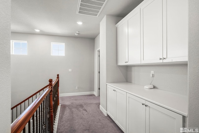 hall with recessed lighting, light colored carpet, visible vents, an upstairs landing, and baseboards