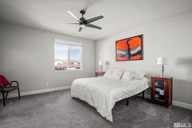 bedroom with a ceiling fan, dark carpet, visible vents, and baseboards