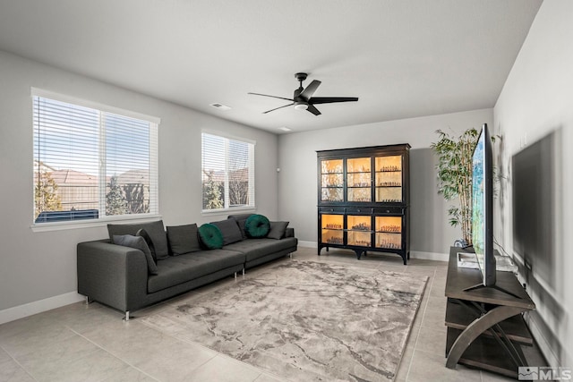 living room featuring a ceiling fan, visible vents, baseboards, and light tile patterned flooring