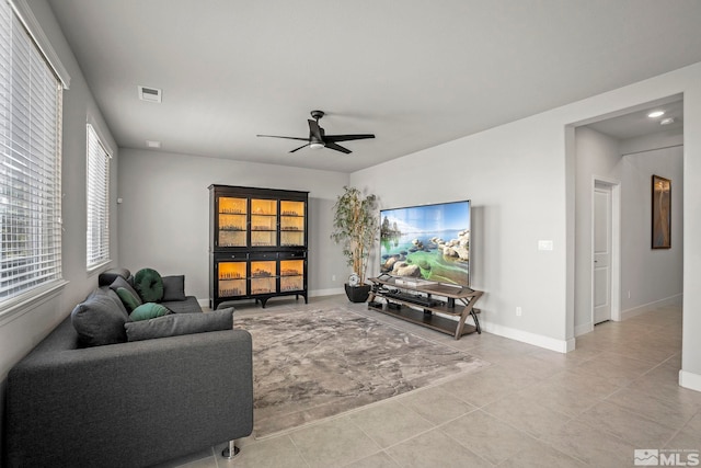 tiled living room featuring baseboards, visible vents, and ceiling fan