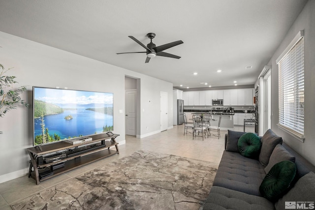 living area with light tile patterned floors, recessed lighting, a ceiling fan, and baseboards