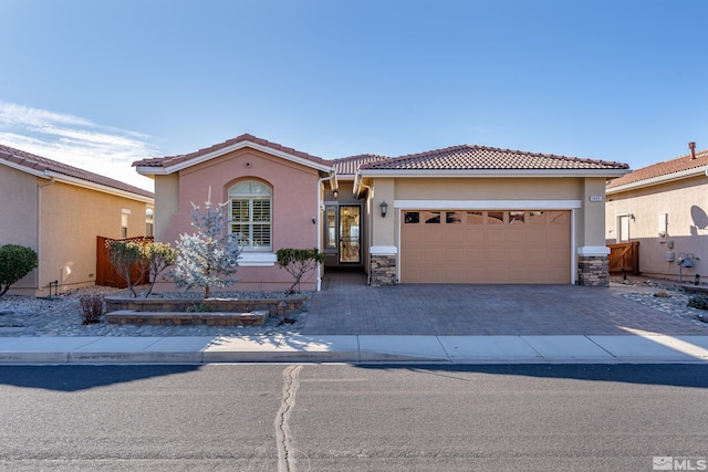 view of front of property featuring a garage, stone siding, decorative driveway, and stucco siding