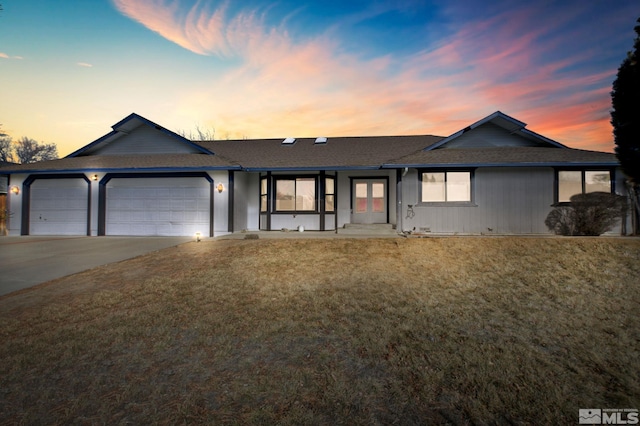 single story home with a front yard, concrete driveway, and an attached garage