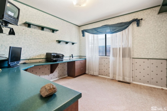 office area with light carpet, wallpapered walls, visible vents, and ornamental molding