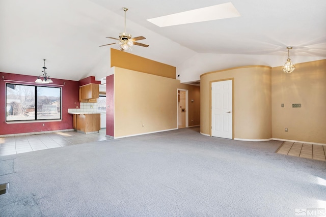 unfurnished living room with lofted ceiling with skylight, light tile patterned flooring, a ceiling fan, and light colored carpet