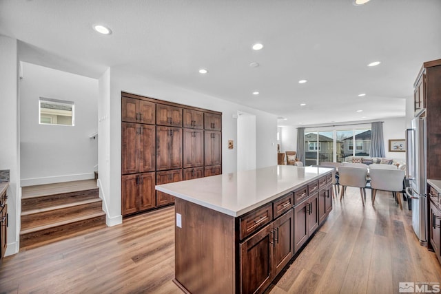 kitchen with recessed lighting, light wood-style floors, open floor plan, light countertops, and a center island