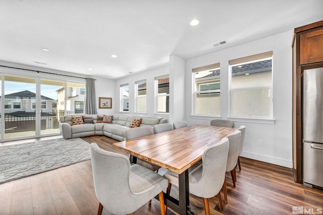 dining area featuring baseboards, visible vents, wood finished floors, and recessed lighting