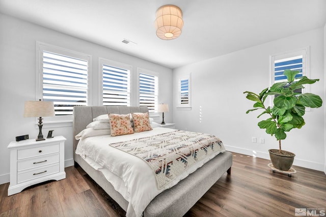 bedroom with dark wood-type flooring, visible vents, and baseboards