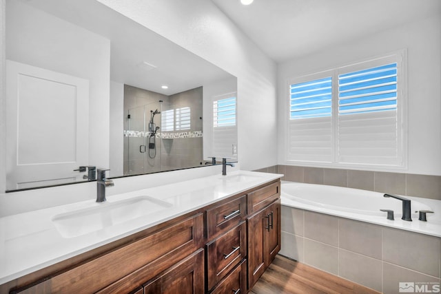 full bath featuring a garden tub, double vanity, a stall shower, and a sink