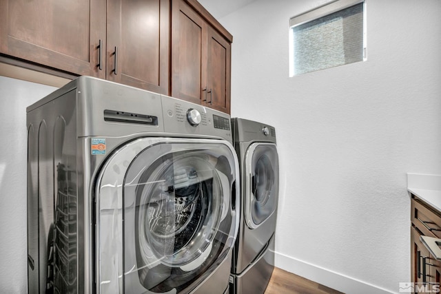 washroom with cabinet space, light wood-style flooring, baseboards, and separate washer and dryer