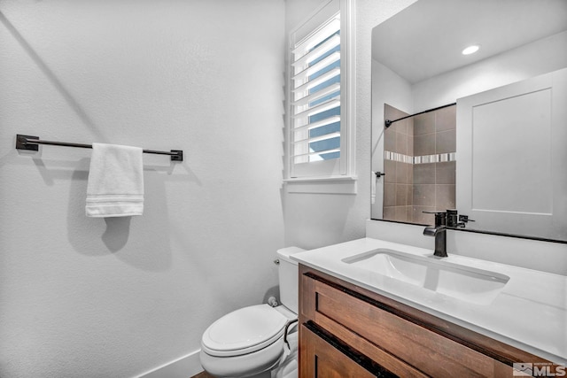 bathroom with toilet, baseboards, and vanity