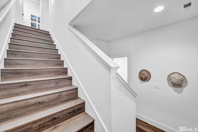 staircase with recessed lighting, wood finished floors, visible vents, and baseboards