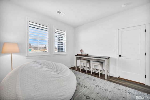 bedroom with visible vents, dark wood finished floors, and baseboards