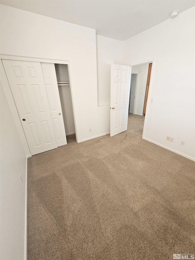 unfurnished bedroom featuring a closet, baseboards, and carpet flooring