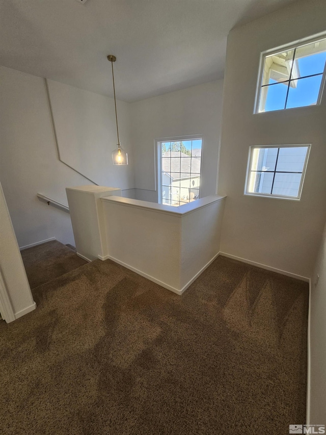 interior space with dark colored carpet and baseboards