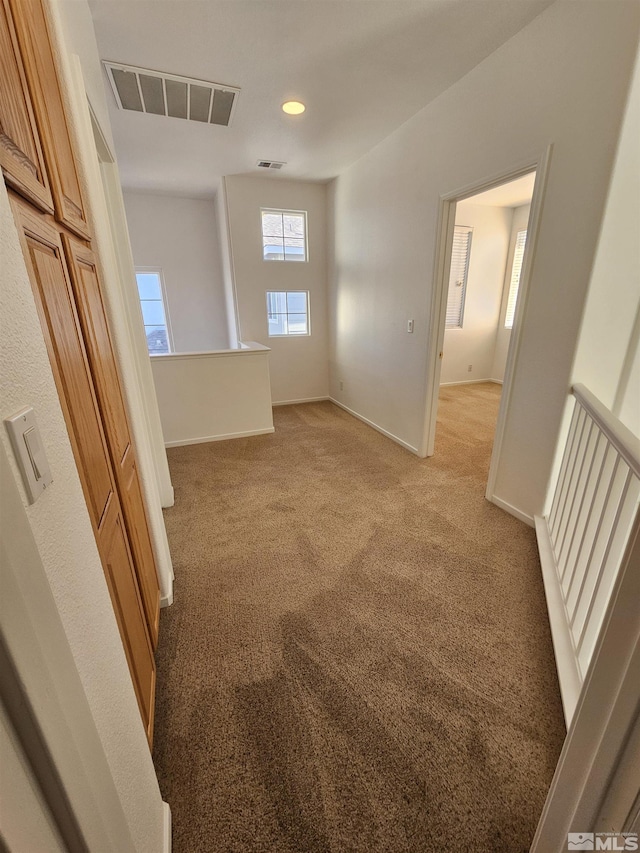 unfurnished room with light carpet, recessed lighting, visible vents, and baseboards