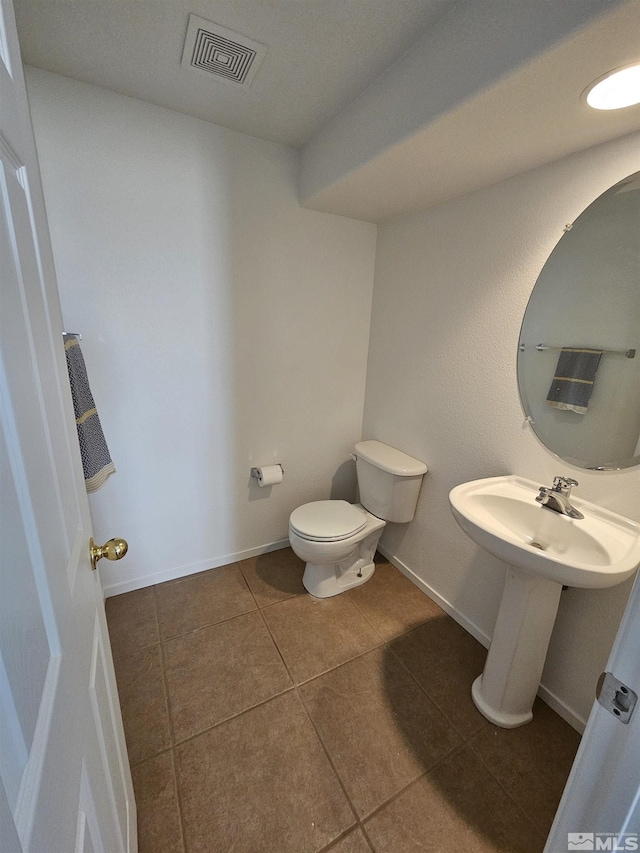 bathroom with toilet, tile patterned flooring, visible vents, and baseboards