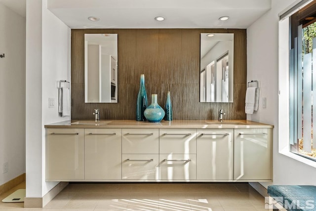 full bathroom featuring double vanity, tile patterned flooring, and a sink