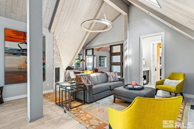 living room with high vaulted ceiling, light wood-style flooring, baseboards, and beam ceiling