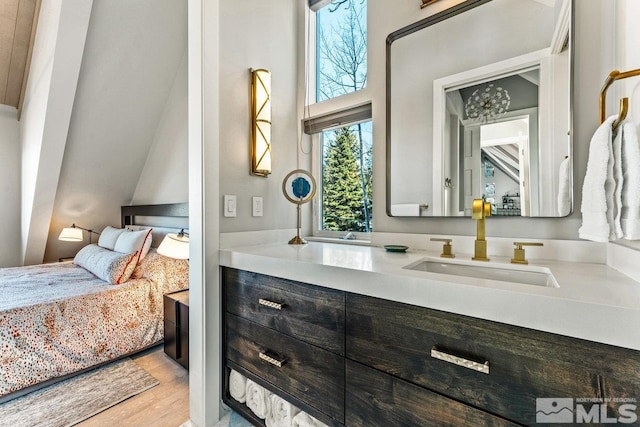 ensuite bathroom featuring connected bathroom, wood finished floors, and vanity