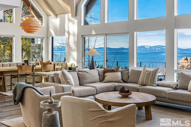 sunroom featuring beamed ceiling and a water and mountain view