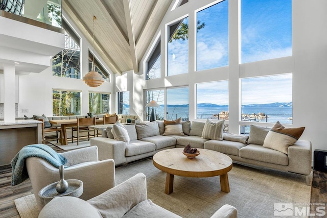 sunroom featuring a water and mountain view