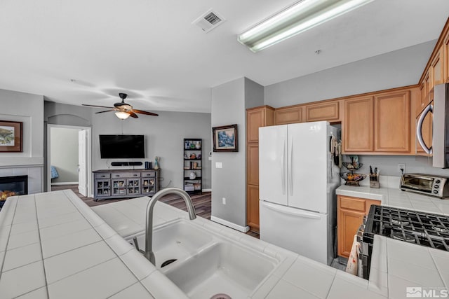 kitchen with tile counters, open floor plan, stainless steel appliances, and visible vents