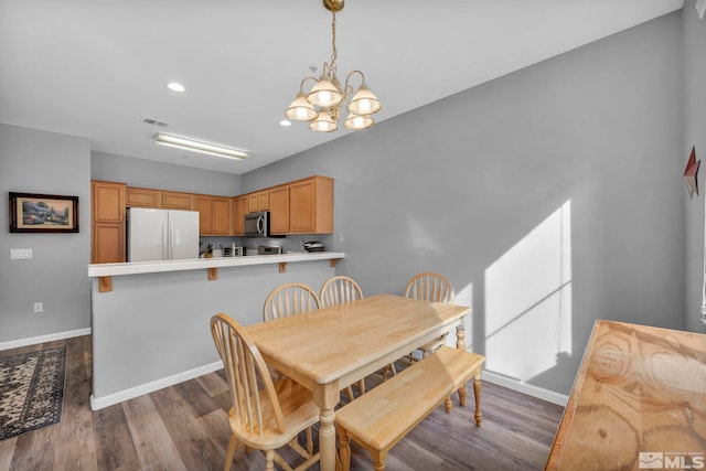 dining room featuring light wood-style floors, baseboards, visible vents, and a chandelier